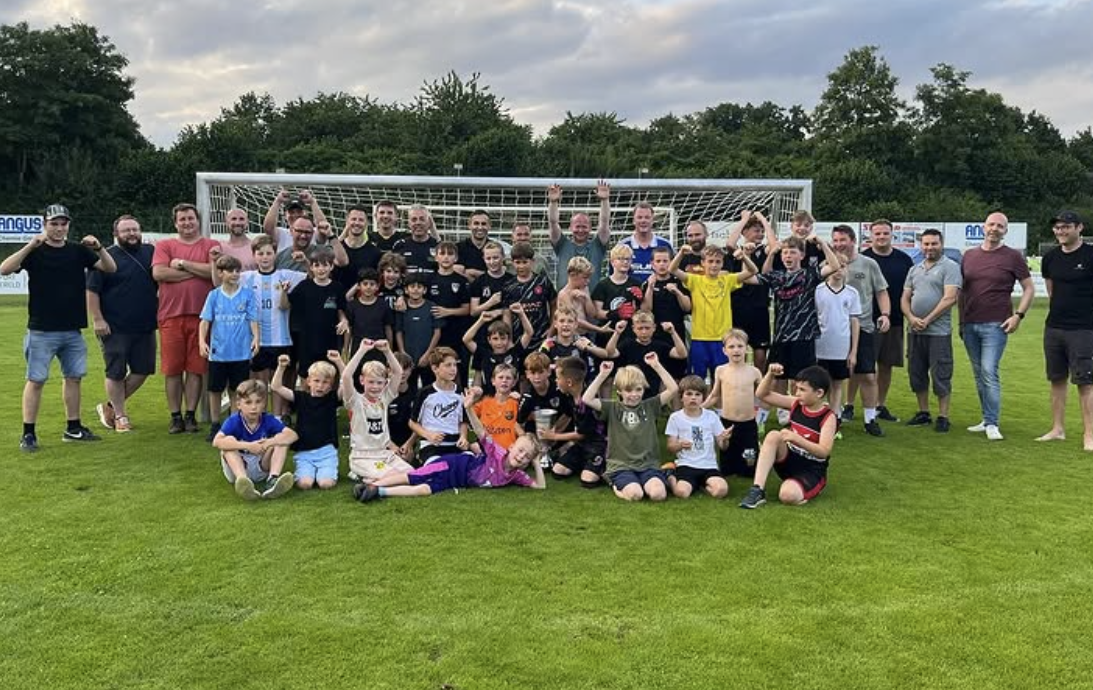 Jugendfußball-Gruppe mit Trainern und Eltern